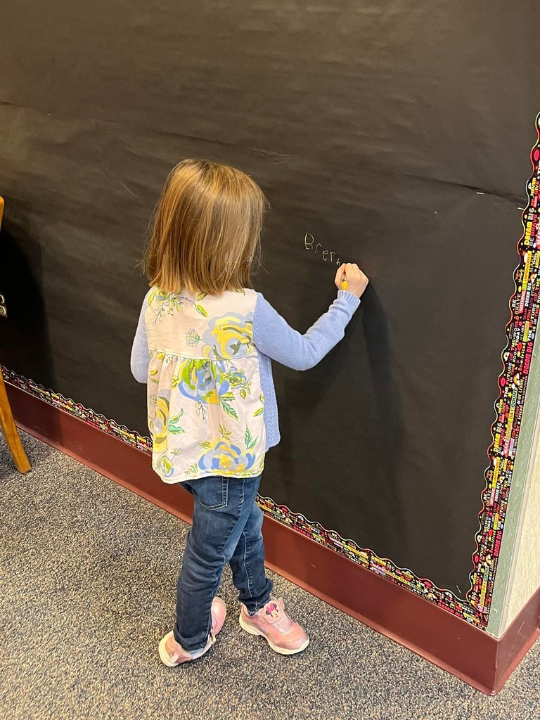young student signing name on wall